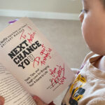 child looking at Brittany Wagner signed book